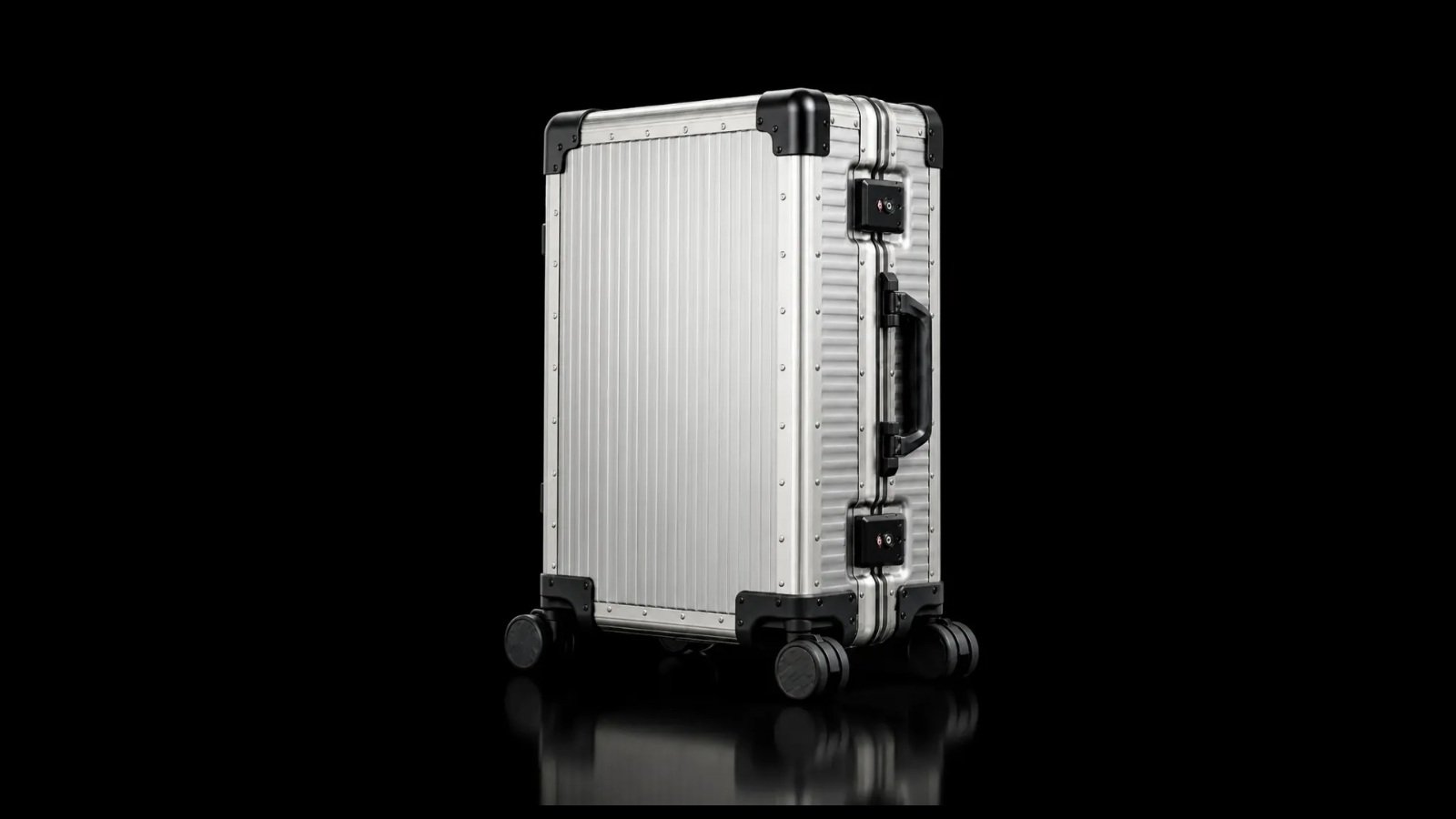 Silver TT-001 suitcase with black corner guards and spinner wheels