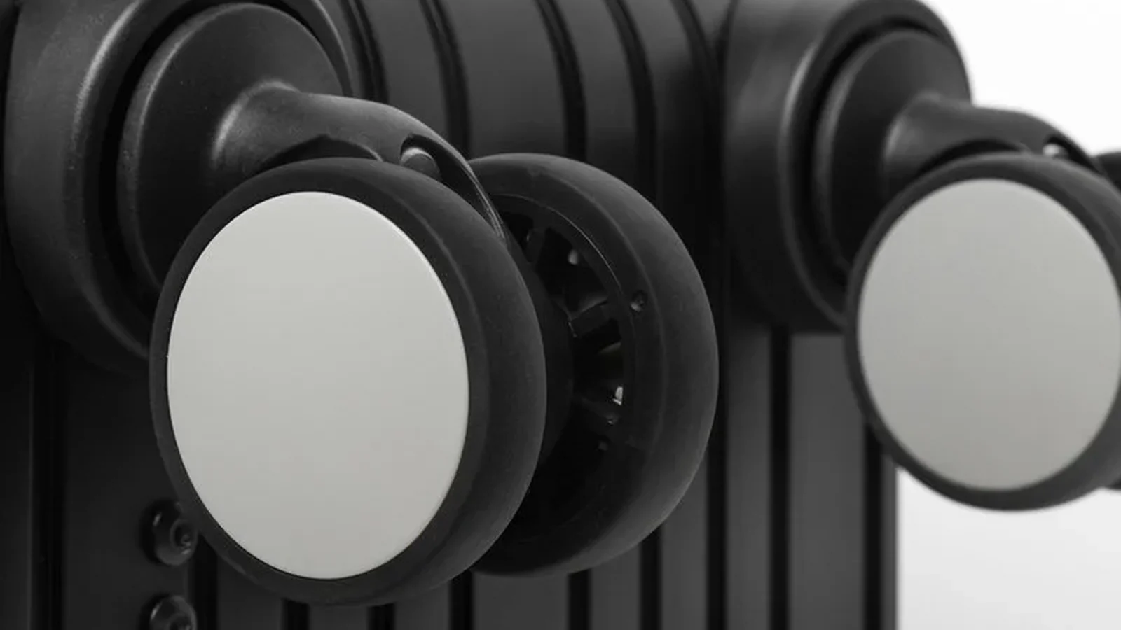 Close-up of double spinner assemblies and housings on a black suitcase
